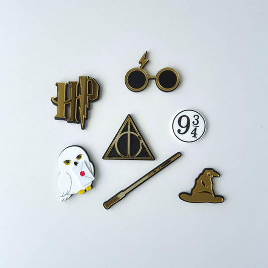 Collection of Harry Potter-themed charms on a white background