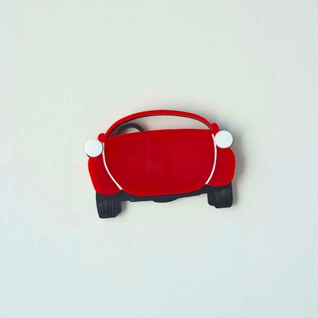 Red car-shaped object with white accents on a white background