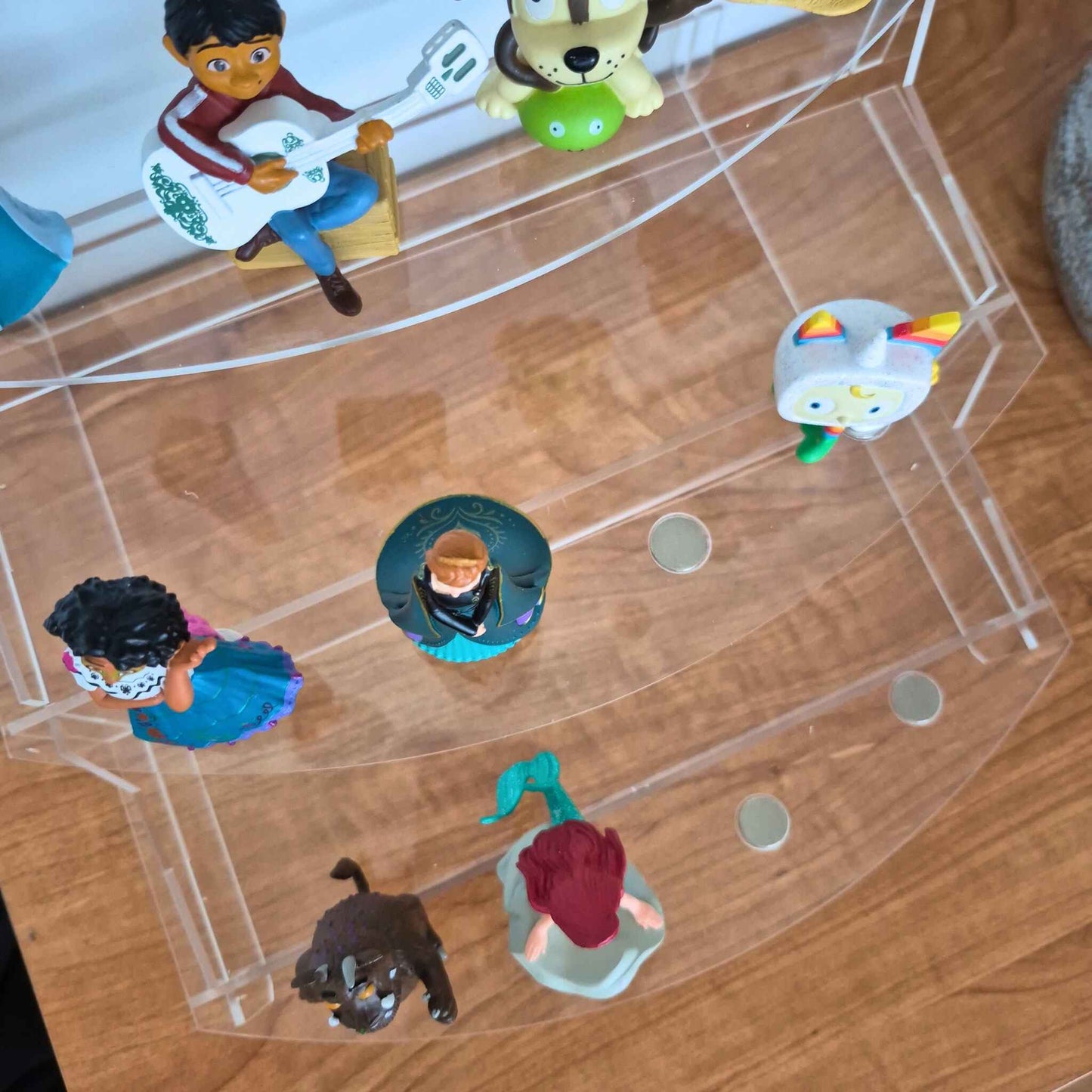 Collection of small figurines on a transparent stand.